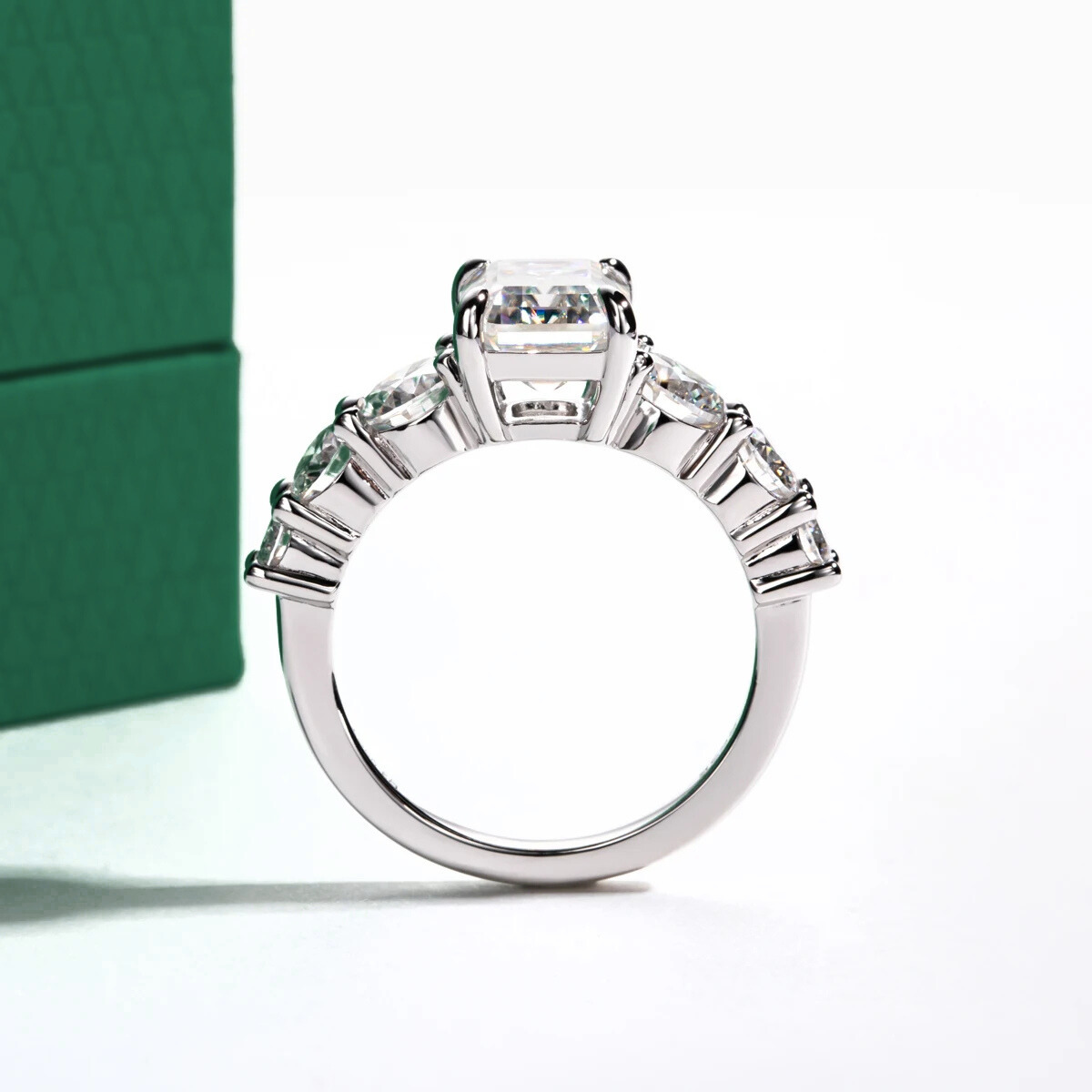 Anel de prata com pedra central moissanite quadrada de 3 quilates e moissanites laterais em fundo branco