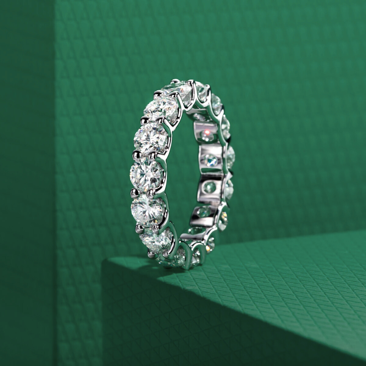 Aliança solitária com moissanites redondos brilhantes em fundo verde texturizado