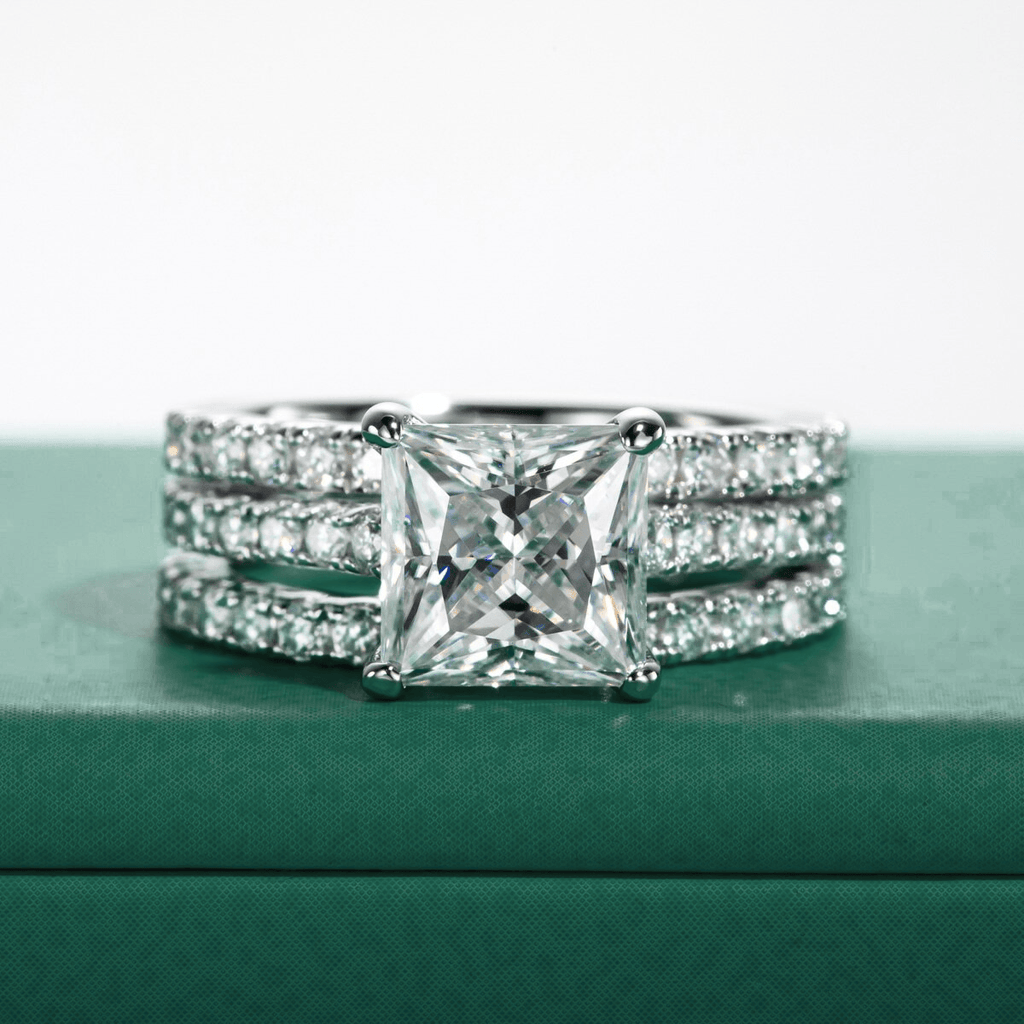 Anel solitário Princess Moissanite com três bandas cravejadas de pequenas alianças de diamantes
