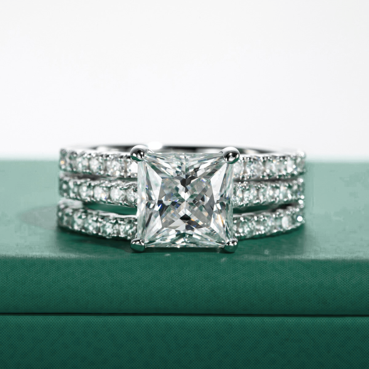 Anel solitário Princess Moissanite com três bandas cravejadas de pequenas alianças de diamantes