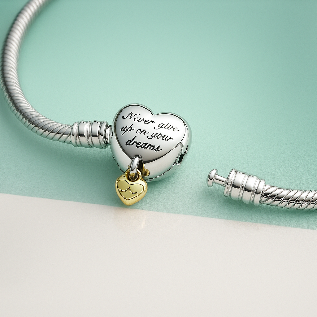 Pulseira prata com pingente de coração gravado com a frase Never give up on your dreams e pingente pequeno dourado